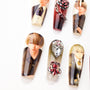 Handmade press-on nails with anime-inspired character designs and gemstone accents