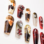Handmade press-on nails with detailed character art, 3D jewels, and red-black designs on white background